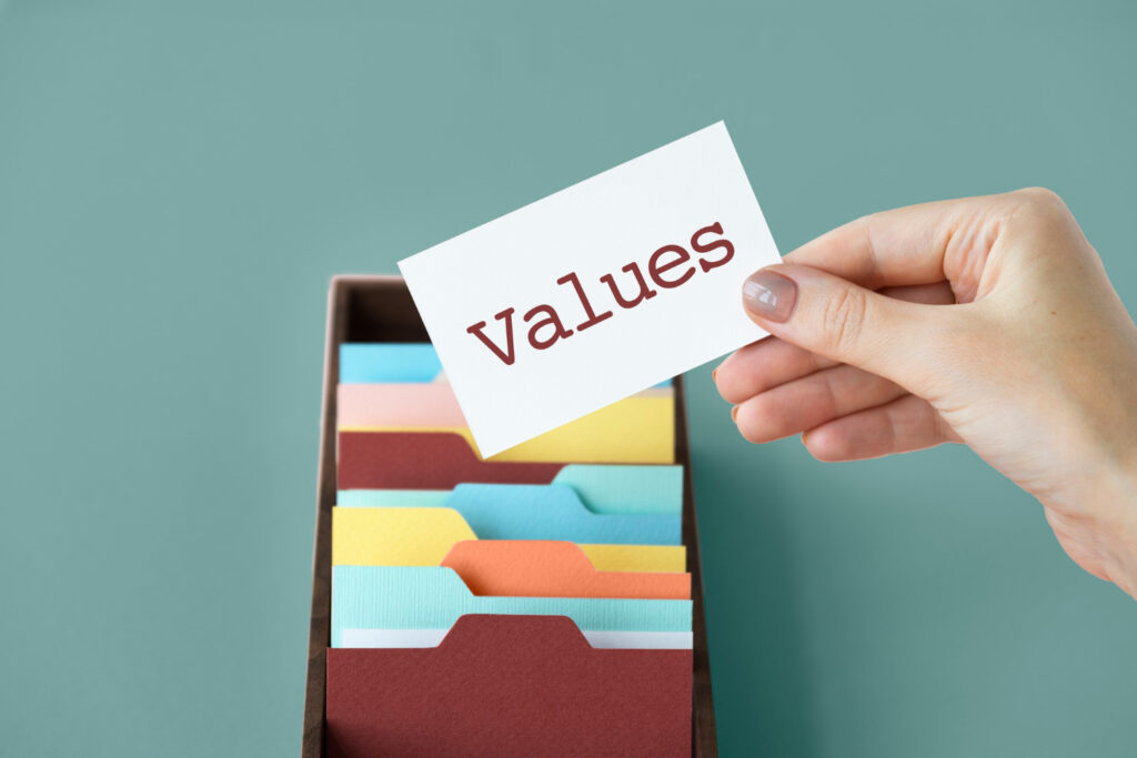 Une main tenant une carte avec le mot 'Values', symbolisant les valeurs fondamentales de Skilloza : innovation, accessibilité et engagement envers la réussite des apprenants.